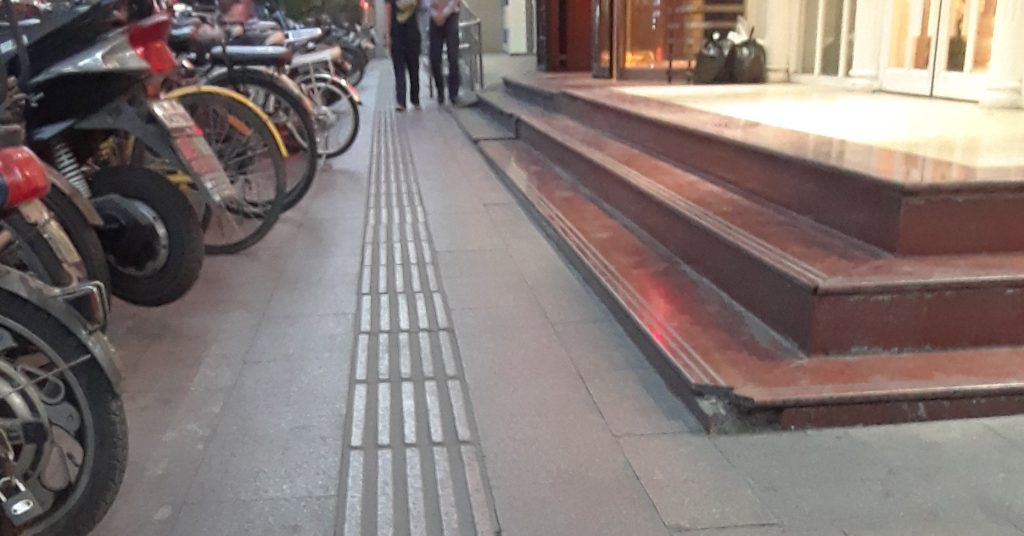 Sidewalk pathway with bikes on the left and steps on the right