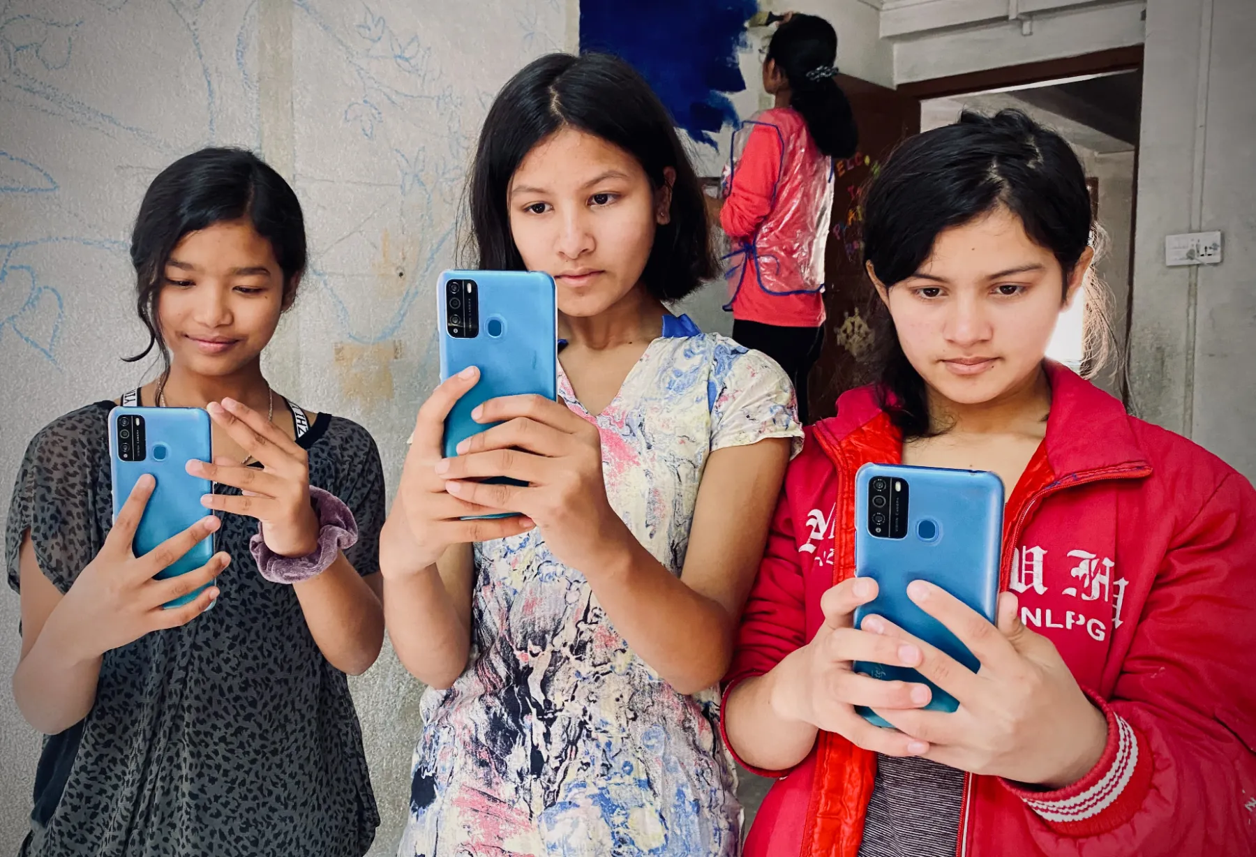 Three individuals using blue phones to take pictures