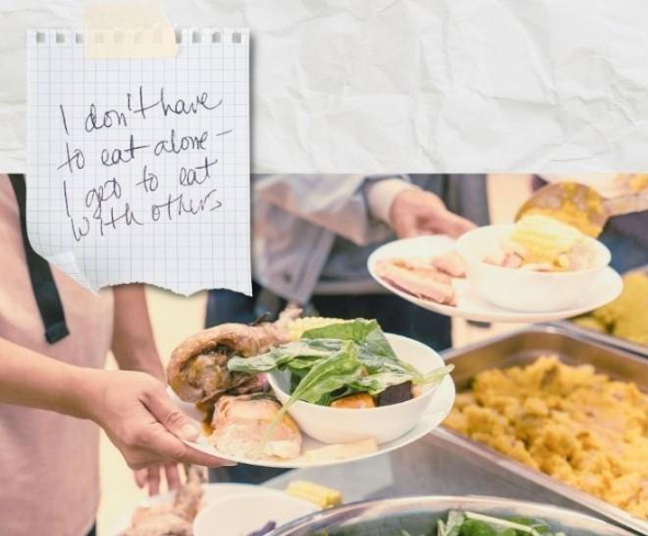 People getting food through a buffet line. In the corner, a note states "I don't have to eat alone - I get to eat with others"